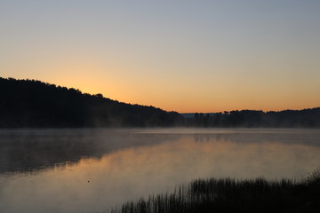 Obraz na płótnie Canvas Sunrise over misty lake