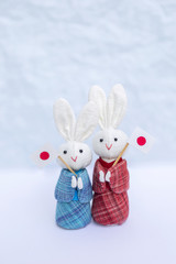 Cute little handmade fabric rabbit doll in Japanese traditional dress holding Japan flag over blurred background, vertical style, Japan tourism concept