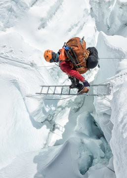 Mountaineer crossing icefall on ladder
