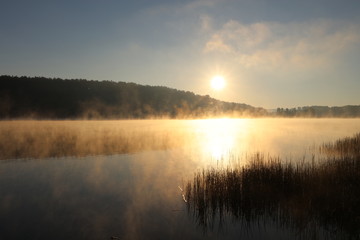 Sunrise over misty lake