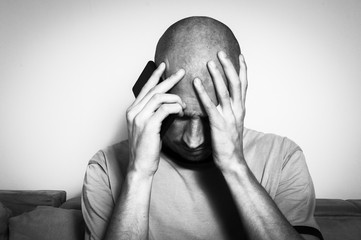 Severe migraine attack on the man after prolonged use of the mobile phone, black and white
