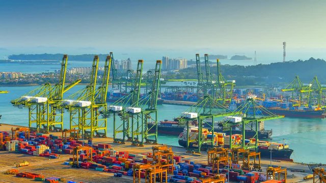 4K Time-lapse video of Container Cargo freight ship with working crane loading bridge in Singapore Port