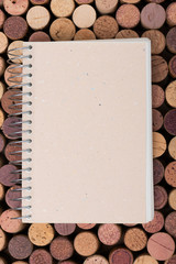 Wine cork stoppers background with open notebook Top view Vertical