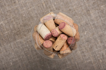 Wine cork stoppers in glass on canvas background Top view Close up Selective Focus