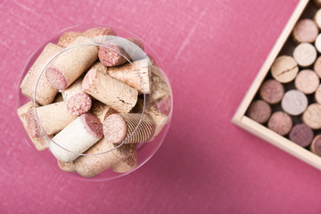 Wine cork stoppers in glass Fuchsia background Top view  Сlose up Selective Focus