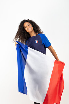 Portrait d'une jeune supportrice de l'équipe de France de football portant un chapeau , des lunettes tricolore et une écharpe de son équipe	