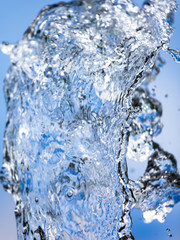 Splashing water with drops on the sky background