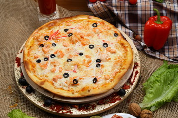 pizza thin olive shrimp crabs on a wooden stand 