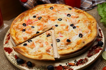 pizza thin olive shrimp crabs on a wooden stand 