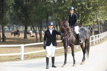 Cheerful Chinese couple riding horse