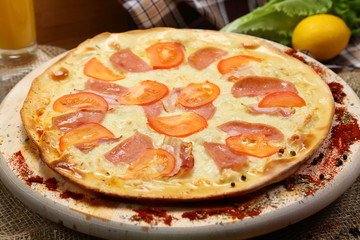 Pizza thin with sausage, bacon, spices