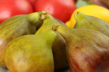 Group of a fresh ripe figs lie in a plate on the table. Selective focus