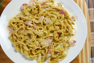 Macaroni of Carbonara with smoked sausage, bacon, sauce. Tasty lunch in the Italian restaurant with herbs, dill