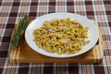 Macaroni of Carbonara with smoked sausage, bacon, sauce. Tasty lunch in the Italian restaurant with herbs, dill