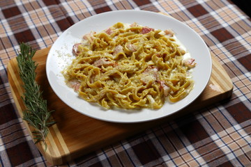 Macaroni of Carbonara with smoked sausage, bacon, sauce. Tasty lunch in the Italian restaurant with herbs, dill