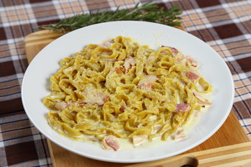 Macaroni of Carbonara with smoked sausage, bacon, sauce. Tasty lunch in the Italian restaurant with herbs, dill