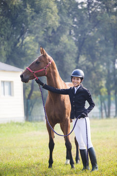 Cheerful Chinese female rider with her horse 