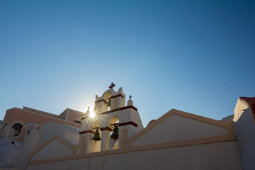 Romantic Sun diffraction near church in Santorini. Fira, Greece. Amazing daytime view towards the...