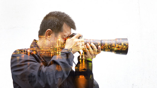Double exposure of photographer wit the city