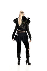 full length portrait of blonde girl wearing lack fantasy warrior outfit. standing pose wit bak to the camera. isolated on white studio background.