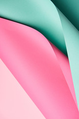 close-up view of bright turquoise and pink colored paper textured background
