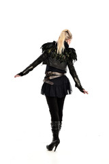 full length portrait of blonde girl wearing lack fantasy warrior outfit. standing pose wit bak to the camera. isolated on white studio background.