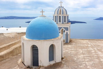 Fototapeta na wymiar Typical chapels with blue domes in Fira Santorini Greece