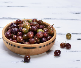 ripe red berries of gooseberries in a brown  bowl