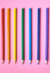 Color pencils on pink pastel background, close up. Set of colorful pencils, copy space. Crayons. Top view, flat lay. Rainbow. Back to school, college concept. Abstract background