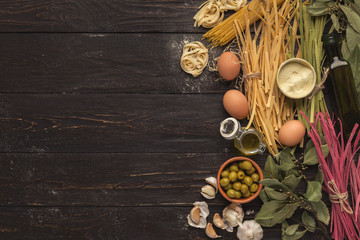 Assorted colorful pasta bowls on rustic wood, top view