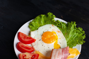 Fried eggs with bacon on the wooden table