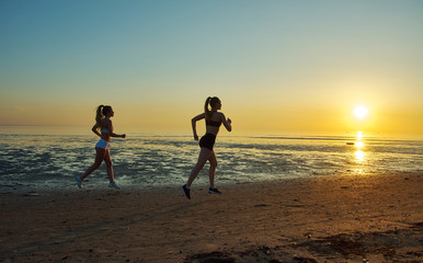 Fototapeta premium two girl running by the sea on the beach