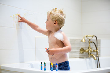 Kind malt im Badezimmer