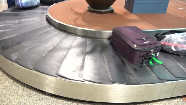 4K movie of Airport baggage claim with luggage spinning around conveyor.
