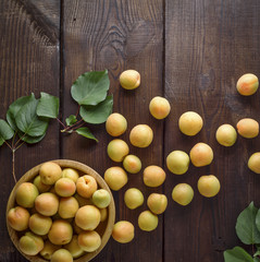 ripe apricots scattered on a brown wooden table