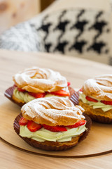 Paris Brest, Cream puff rings with pistachio cream and fresh strawberry, traditional french choux pastry