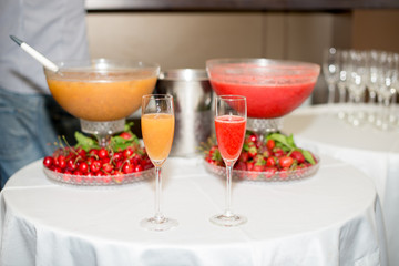 cocktail in a glass of champagne, punch and fruit in the background