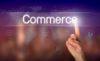A hand selecting a Commerce business concept on a clear screen with a colorful blurred background.