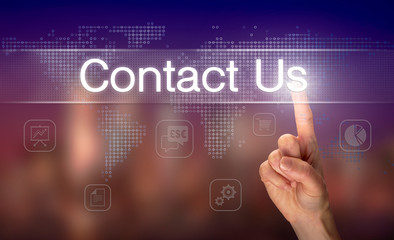 A hand selecting a Contact Us business concept on a clear screen with a colorful blurred background.