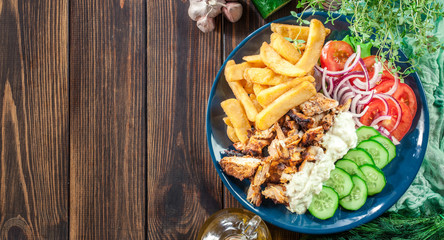 Greek gyros dish with french fries and vegetables