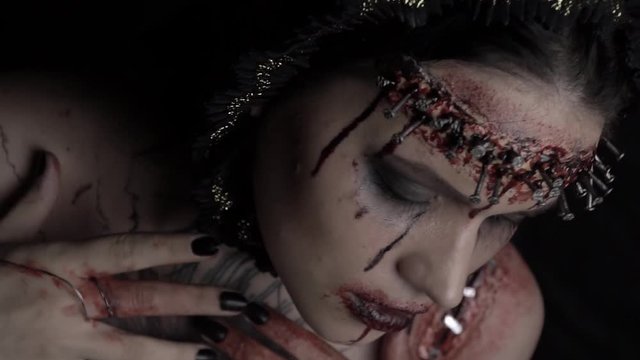 Bloody stains on the face from the nails in the head