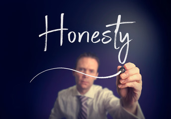 A businessman writing a honesty concept with a white pen on a clear screen.