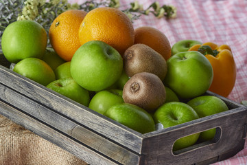 Oranges,kiwis and apples in a wooden crate