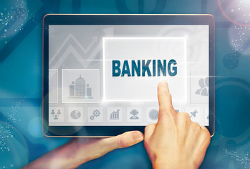 A hand holiding a computer tablet and pressing a banking business concept.