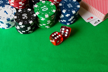 Dice, poker chips and playing cards on the green table . Game concept. Games of chance