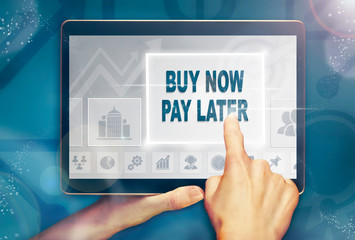 A hand holiding a computer tablet and pressing a buy now pay later business concept.