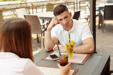 Couple having relationship problems, talking in a cafe