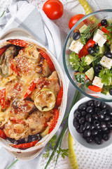 Traditional tasty rustic stew of chicken and vegetables  with Greek salad and black olives