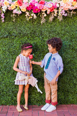 Girl smelling rose holding by boy 