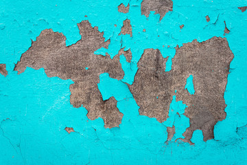 Concrete wall with old cracked blue paint. Texture and background